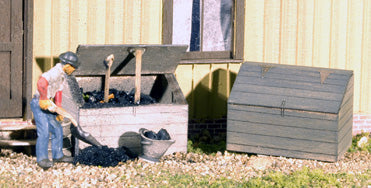 Banta Modelworks 712 O scale coal bin kit, two assembled and painted bins in a model scene; figure and scenery are separate.