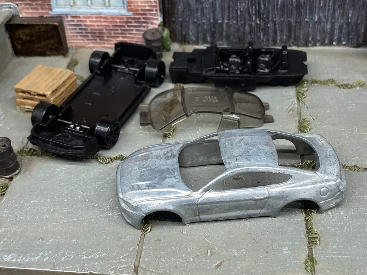 Bare-metal Hot Wheels Mustang body with its base, interior and windows before customization