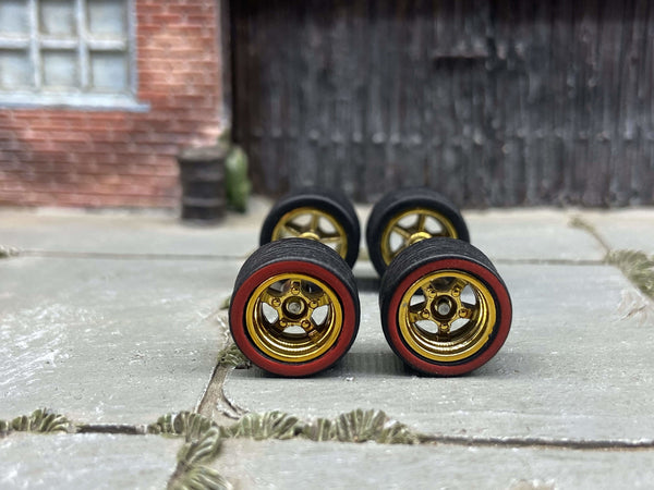 Front view of four 12mm gold five-spoke deep-dish wheels with red-line tires
