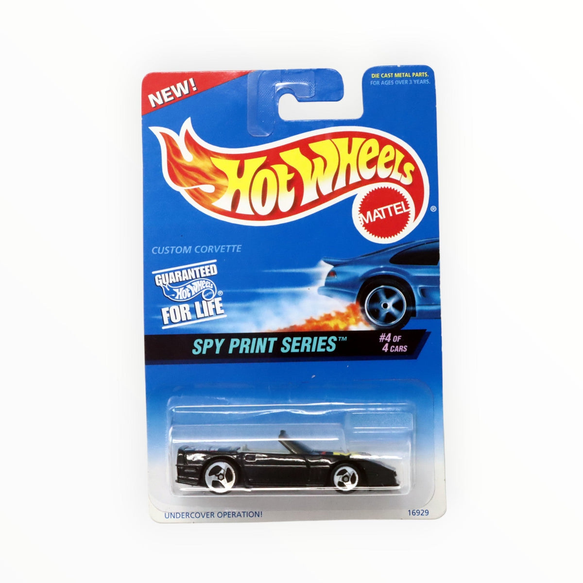 Hot Wheels Custom Corvette negro con ruedas de tres radios, en blíster transparente sobre tarjeta azul Spy Print Series marcada 4 de 4