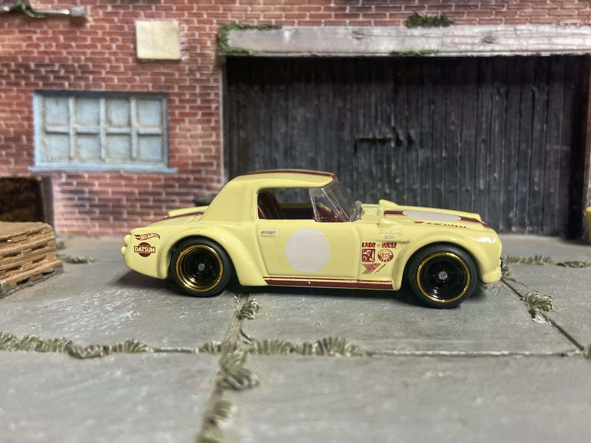 Fairlady 2000 Custom Hot Wheels amarillo y rojo con ruedas negras y doradas de carrera