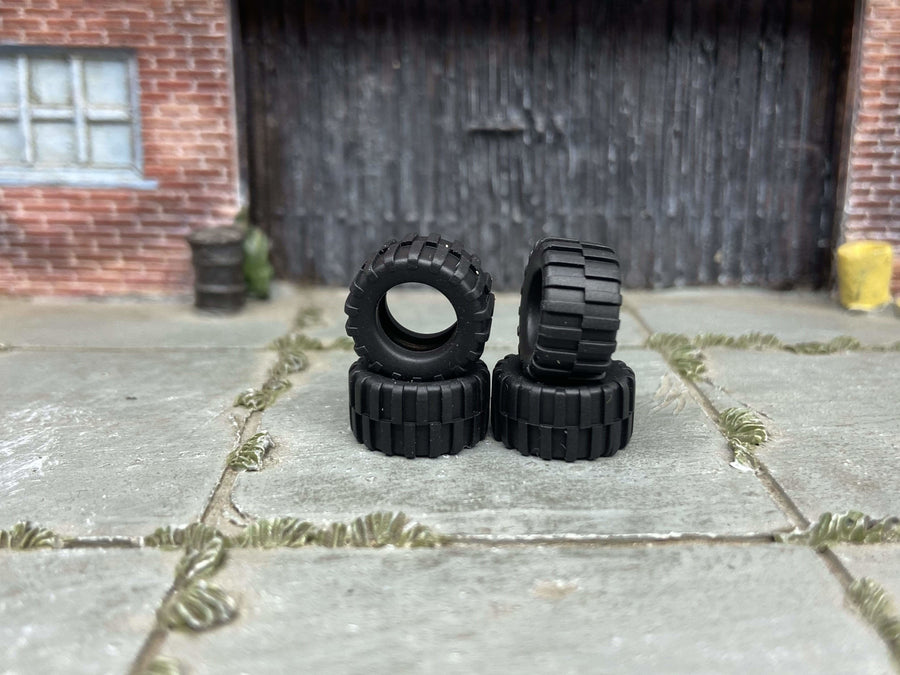 Cuatro neumáticos de goma con dibujo off-road, sin ruedas ni ejes
