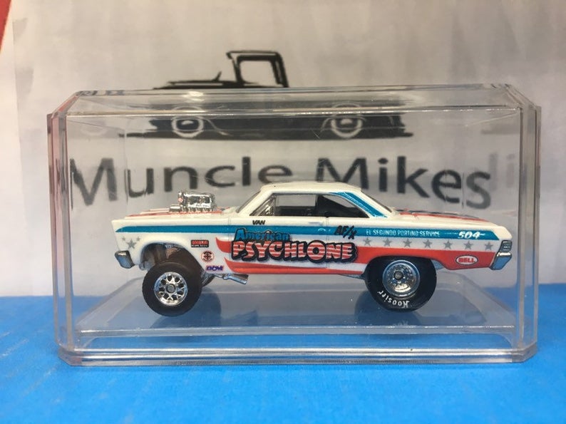 Die-cast drag car displayed in a clear case in front of a Muncle Mikes sign