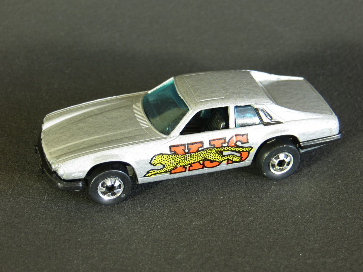 Gray Jaguar XJS with yellow cat over red-orange XJS graphics, blue windows and blackwall wheels