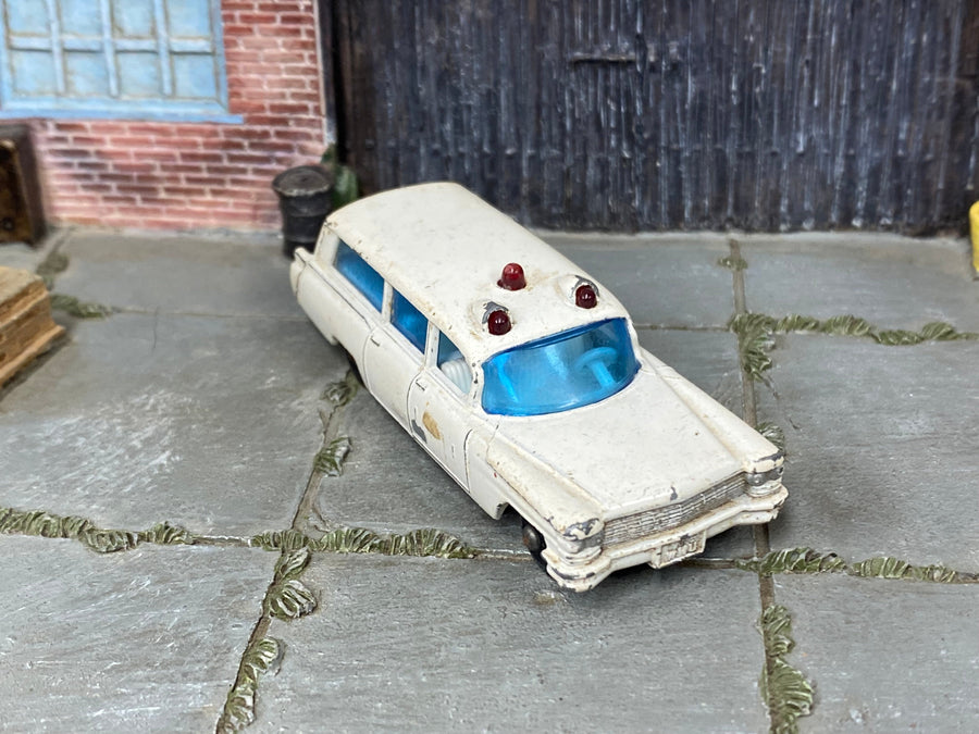 Playworn Lesney Matchbox No.54 Cadillac ambulance photographed for condition assessment, not a before-and-after cleaning demonstration