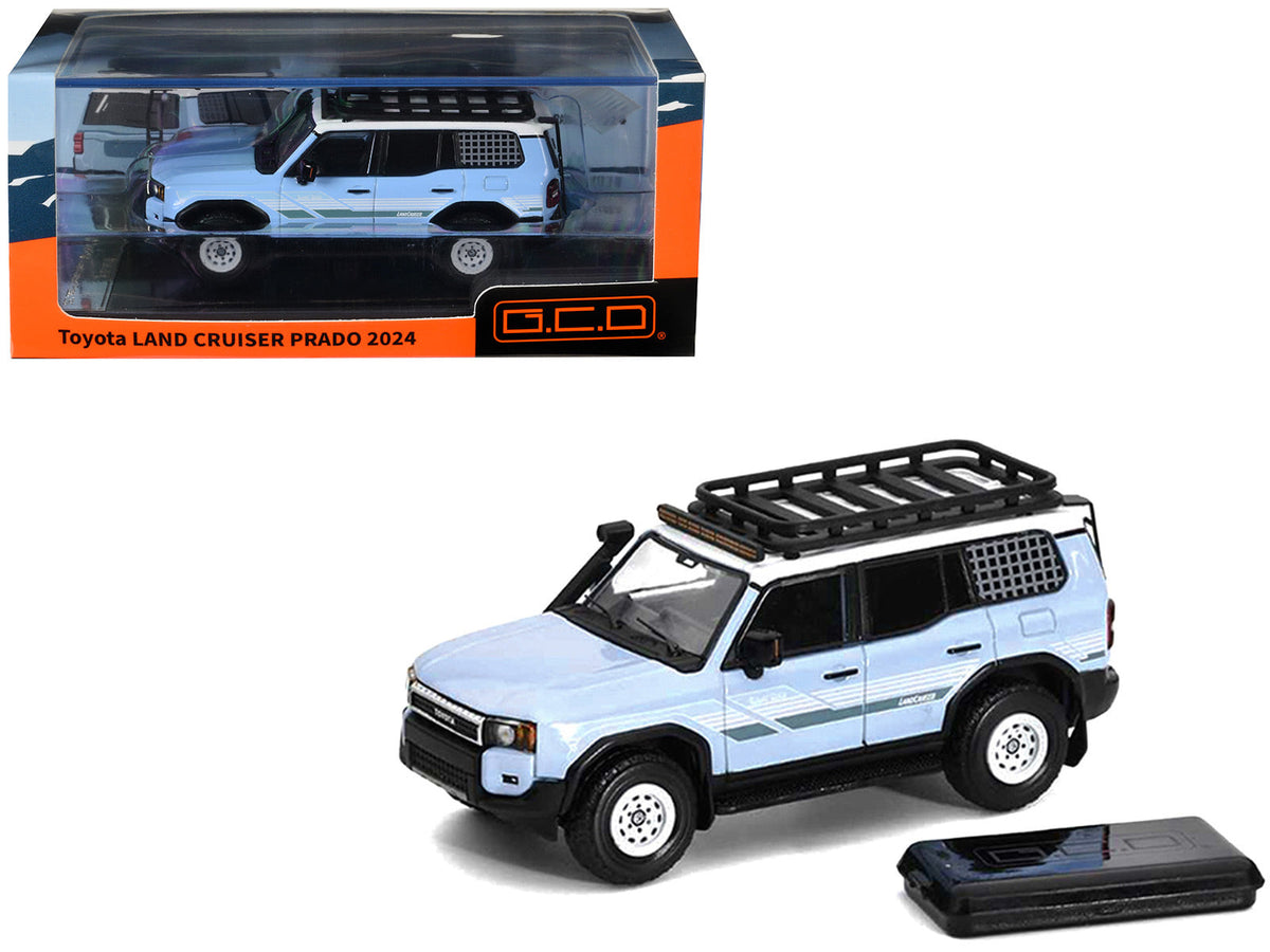 Light blue GCD Prado KS-075-581 with white top, stripes, black roof rack and a separate dark accessory pictured beside it