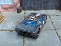 Custom Ford GT-40 showing red-white-and-blue stripes and blue glazing, rear three-quarter view