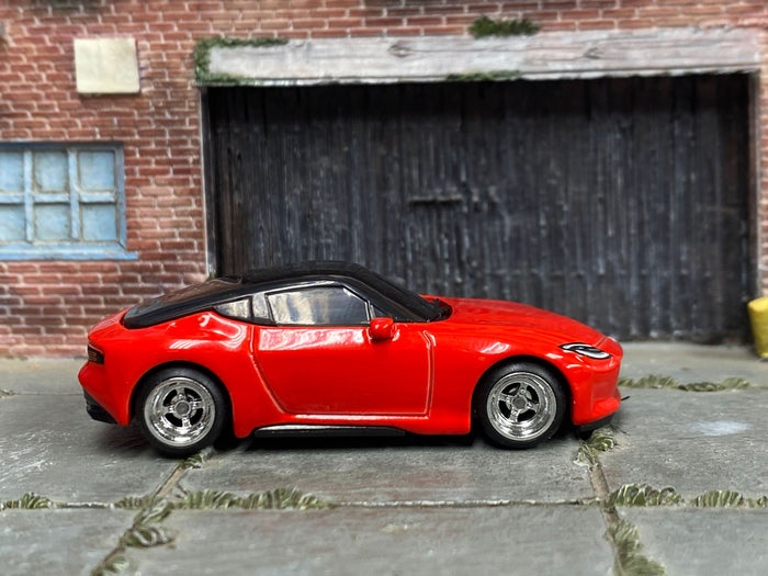 Red custom 2023 Nissan Z with chrome 4-spoke wheels, right-side view