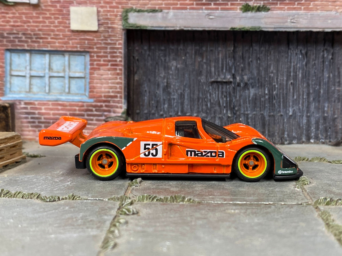 Custom Mazda 787B in orange with orange-and-green mag wheels, front three-quarter view