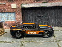 Satin-black custom 2013 COPO Camaro with orange FRAM graphics, right-side view