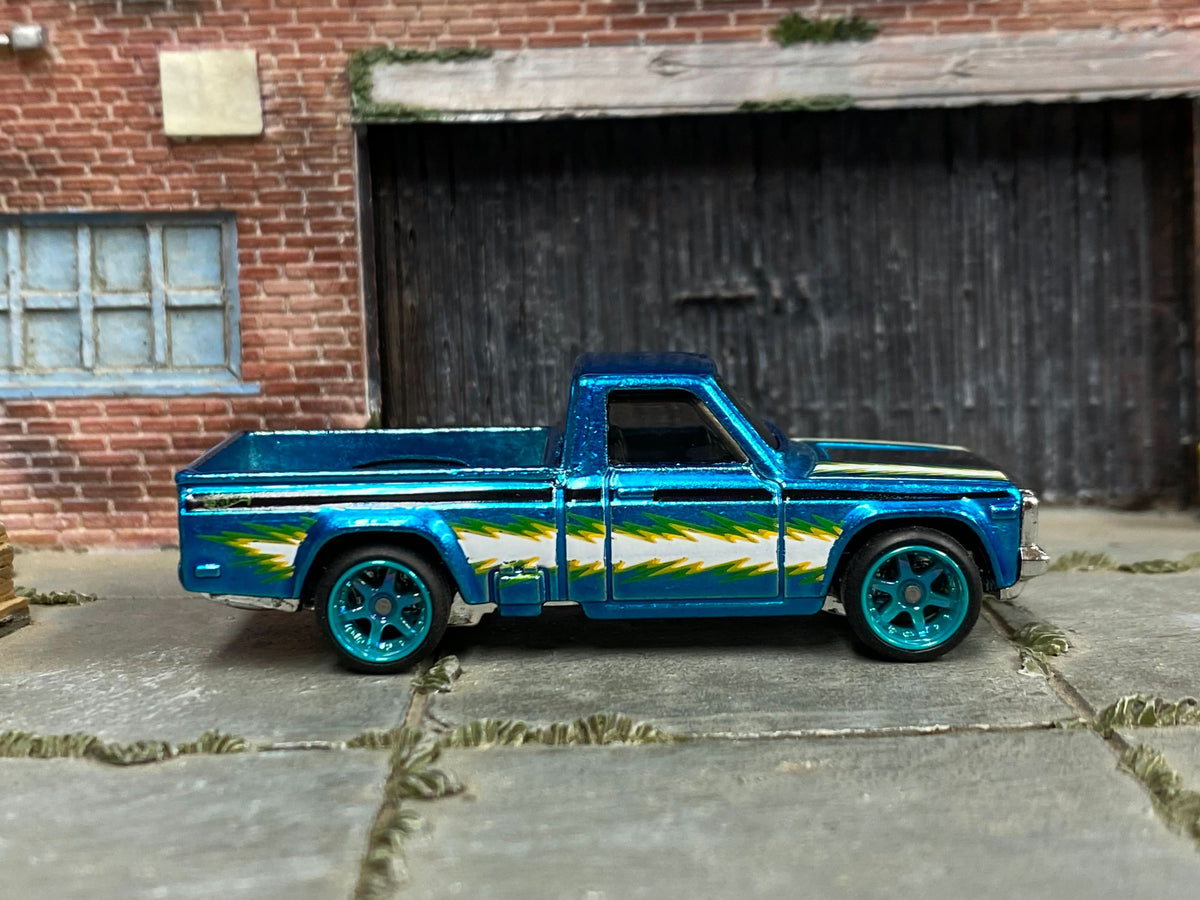 Metallic-blue custom Mazda REPU with lightning graphics and blue wheels, right-side view