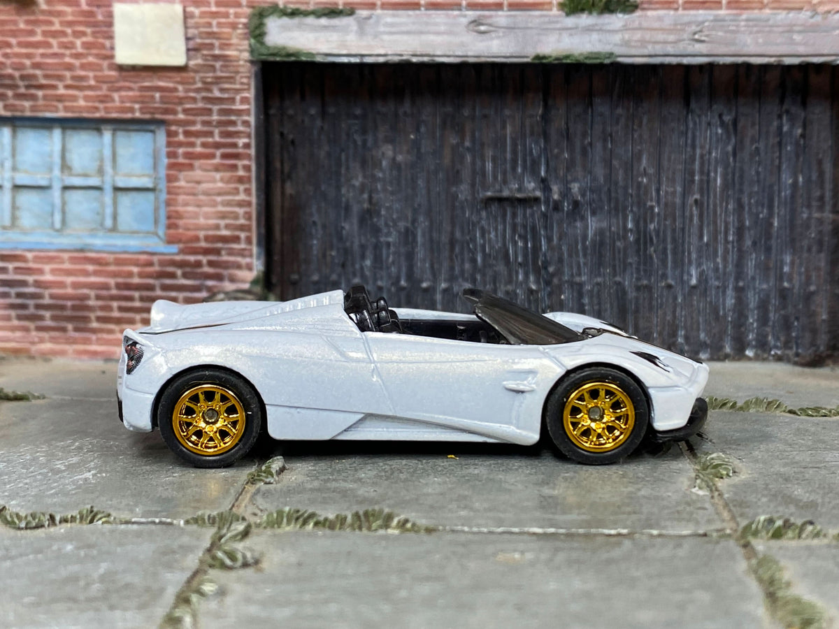 Pearl-white, black and gold Pagani Huayra Roadster, front three-quarter view