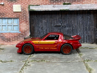 Dark-red-and-gold Mazda RX-7 custom car, opposite side view