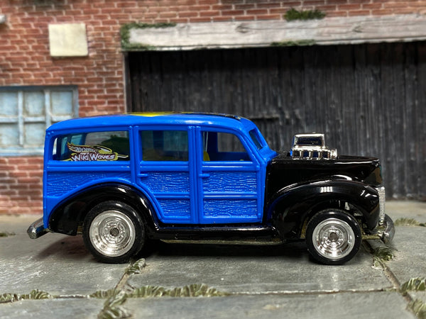 Blue and black custom 1940 Ford Woody with chrome wheels, right-side view