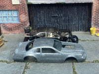 Stripped 1986 Ford Thunderbird Pro Stock body beside its matching donor assembly