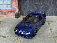 Mazda RX-7 Savanna custom with black-and-chrome mag wheels, side view