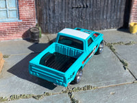 Teal-and-white Mazda REPU custom Hot Wheels, rear view of open pickup bed