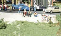 Woodland Scenics A2759 People Sitting in a manufacturer O-scale layout example; surrounding buildings, vehicles and other scenery are not included.