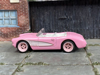 Custom 1956 Chevrolet Corvette with white interior and pink wheels, left-side view