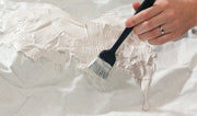 C1186 brush applying plaster to a scenery base; plaster and base not included