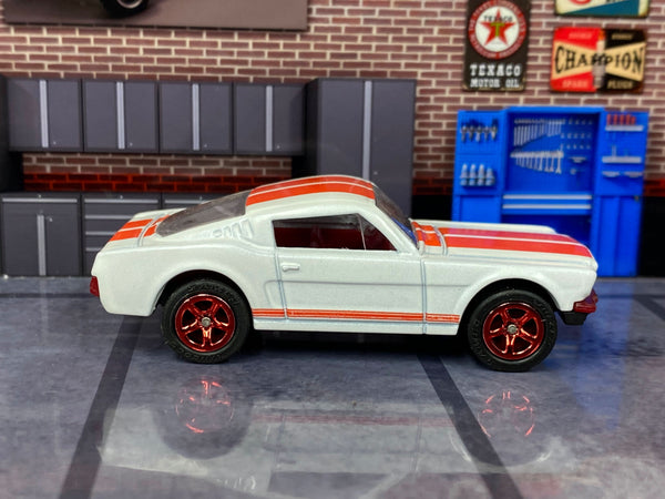 Pearl-white 1965 Mustang GT custom Matchbox, left side with red five-spoke wheels