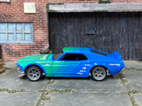 Green-and-blue Mustang Boss 302 custom showing gray wheels and rubber tires
