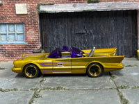 Metallic gold Batman Batmobile with purple graphics, left-side view
