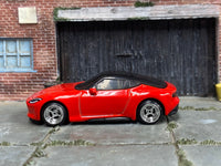 Red custom 2023 Nissan Z with chrome 4-spoke wheels, left-side view
