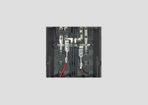 Märklin 74040 red and brown feeder wires attached to underside terminals of example C-track; track is not included.