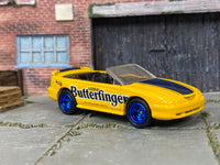 Custom Hot Wheels 1996 Mustang GT Convertible in yellow and blue Butterfinger livery with blue mag wheels and rubber tires