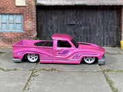 Custom Hot Wheels Bounce'N Bass metallic pink finish with purple graphics and bed-mounted speaker detail with white wheels and rubber tires - side view