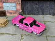 Custom Hot Wheels Bounce'N Bass metallic pink finish with purple graphics and bed-mounted speaker detail with white wheels and rubber tires - three-quarter view