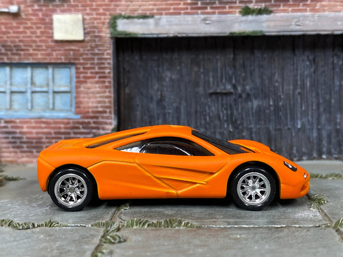Satin-orange McLaren F1 custom Hot Wheels, left side view with chrome wheels