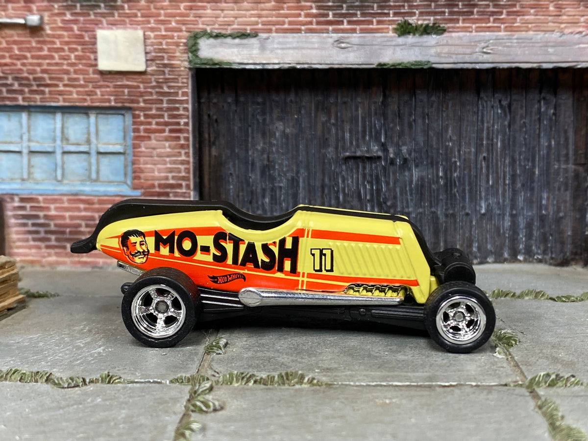 Custom Hot Wheels Mo-Stash cream, orange, and black #11 Mo-Stash livery with chrome wheels and rubber tires - side view
