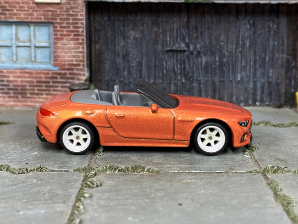 Mercedes-AMG SL 63 metallic-orange custom Matchbox with white wheels, view 1