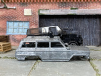Stripped bare-metal 1988 Jeep Wagoneer 4x4 body beside matching kit chassis and components