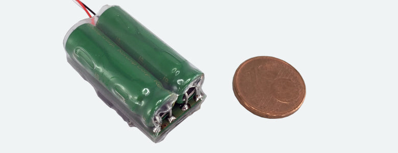 ESU 54672 PowerPack Maxi energy storage module with wire leads; coin shown for size comparison.