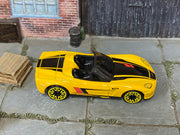 Hot Wheels Corvette C6 Convertible yellow with black and red stripes, top view