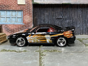 Hot Wheels Saleen S7 black with orange and gold fist graphics right-side view