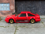 Hot Wheels Toyota AE86 Sprinter Trueno red with black stripes, left side view