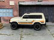 Hot Wheels Toyota Land Cruiser 80 2023 white with orange stripes, left-side view