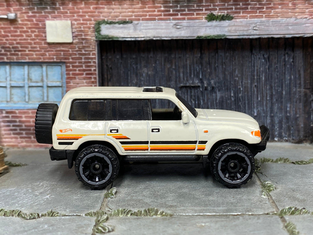 Hot Wheels Toyota Land Cruiser 80 2023 white with orange stripes, right-side view