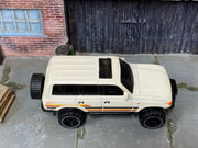 Hot Wheels Toyota Land Cruiser 80 2023 white with orange stripes, top view