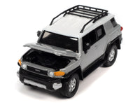 Johnny Lightning 1:64 2007 Toyota FJ Cruiser in Titanium Silver with white roof and roof rack, hood open.
