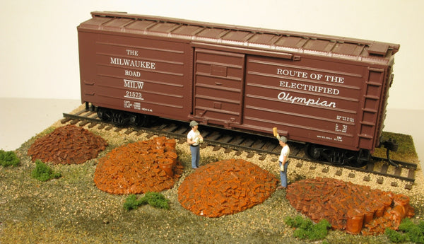 Monroe Models 2107 HO scale railroad tie plate piles with spike buckets, manufacturer layout example; railcar, figures and scenery not included.
