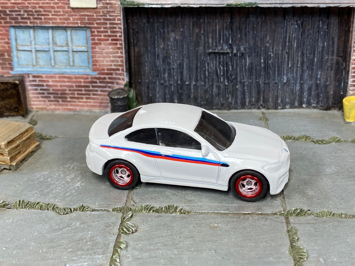2016 BMW M2 custom Hot Wheels in white with M stripes, red and chrome wheels, and rubber tires