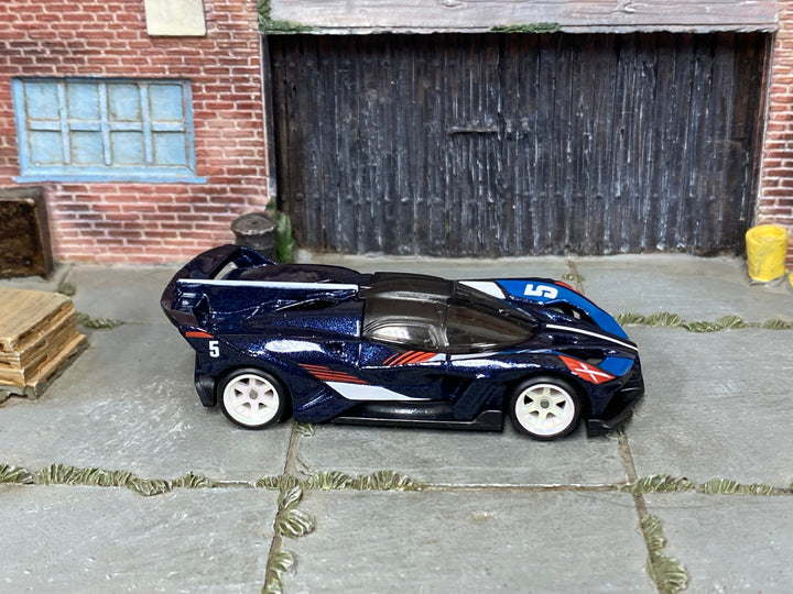 McLaren Solus GT custom Hot Wheels in dark blue number 5 livery with white wheels and rubber tires