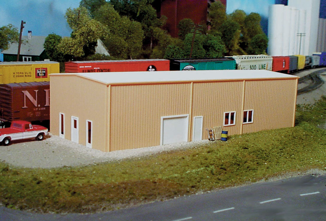 Pikestuff 541-0004 HO prefab warehouse, assembled tan warehouse in a model railroad scene