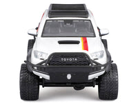 White 2023 Toyota Tacoma TRD Pro off-road pickup with graphics and roof rack, unboxed front view, Maisto 1:27.