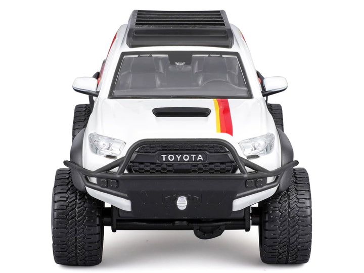 White 2023 Toyota Tacoma TRD Pro off-road pickup with graphics and roof rack, unboxed front view, Maisto 1:27.
